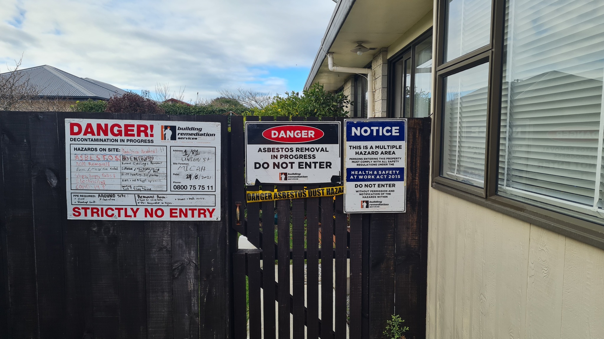 Domestic property secured with asbestos removal and hazard signage