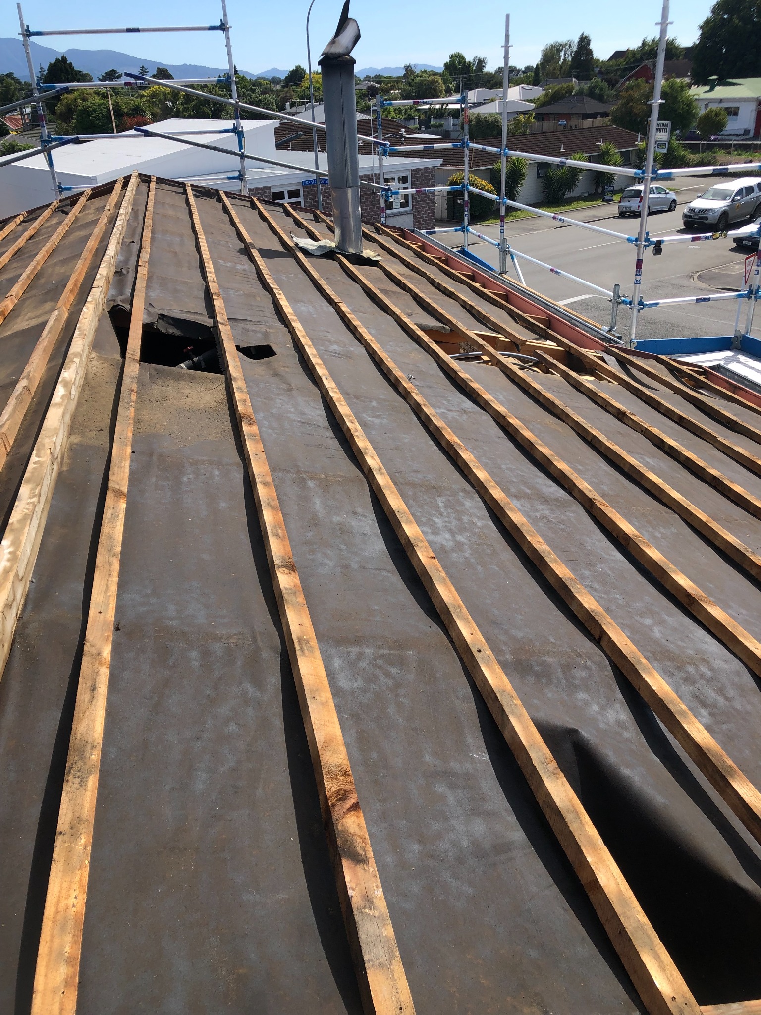 Smaller roof project with roof covering removed and edge scaffolding installed